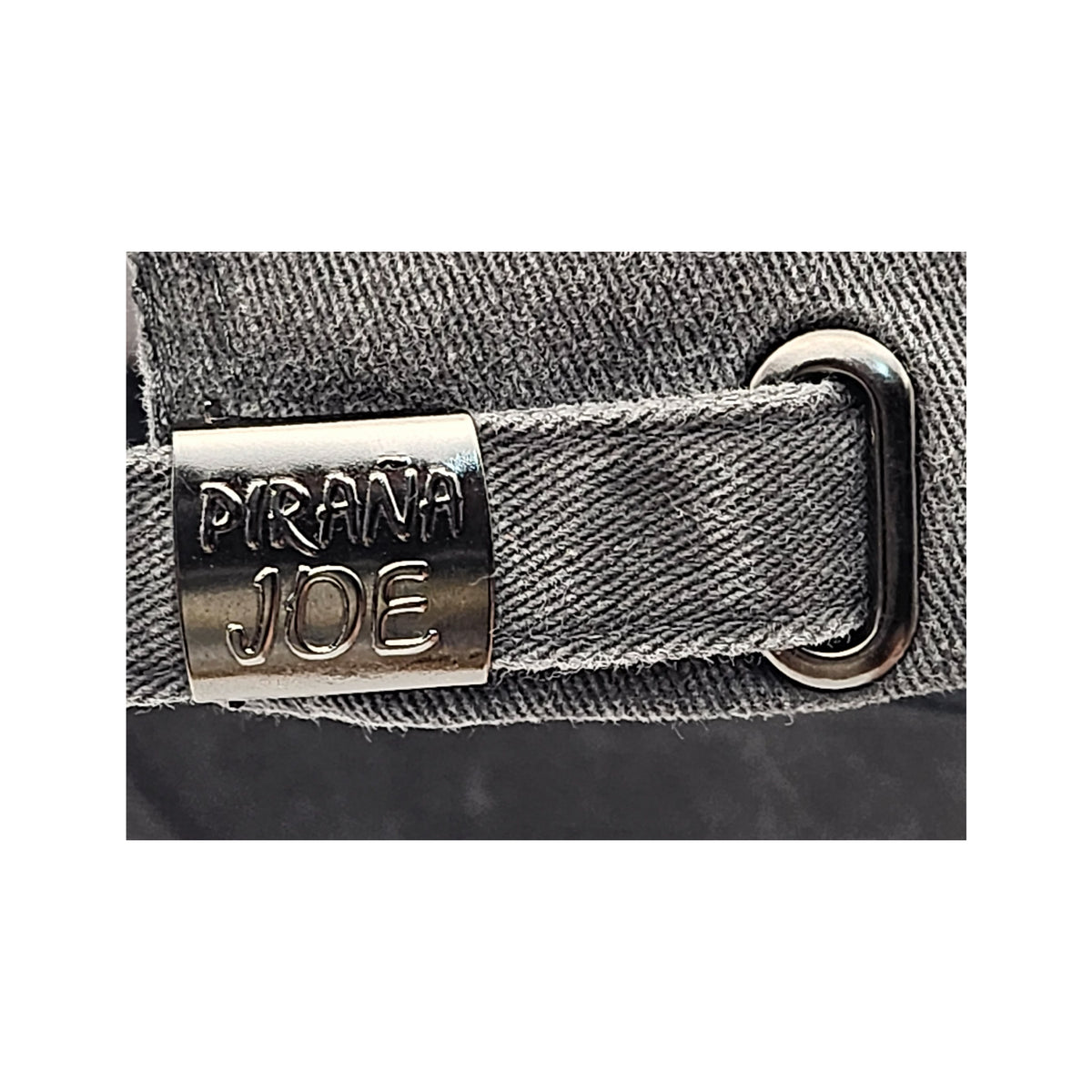 Piraña Joe Originals washed cap in black – detail of the metal strap buckle with logo